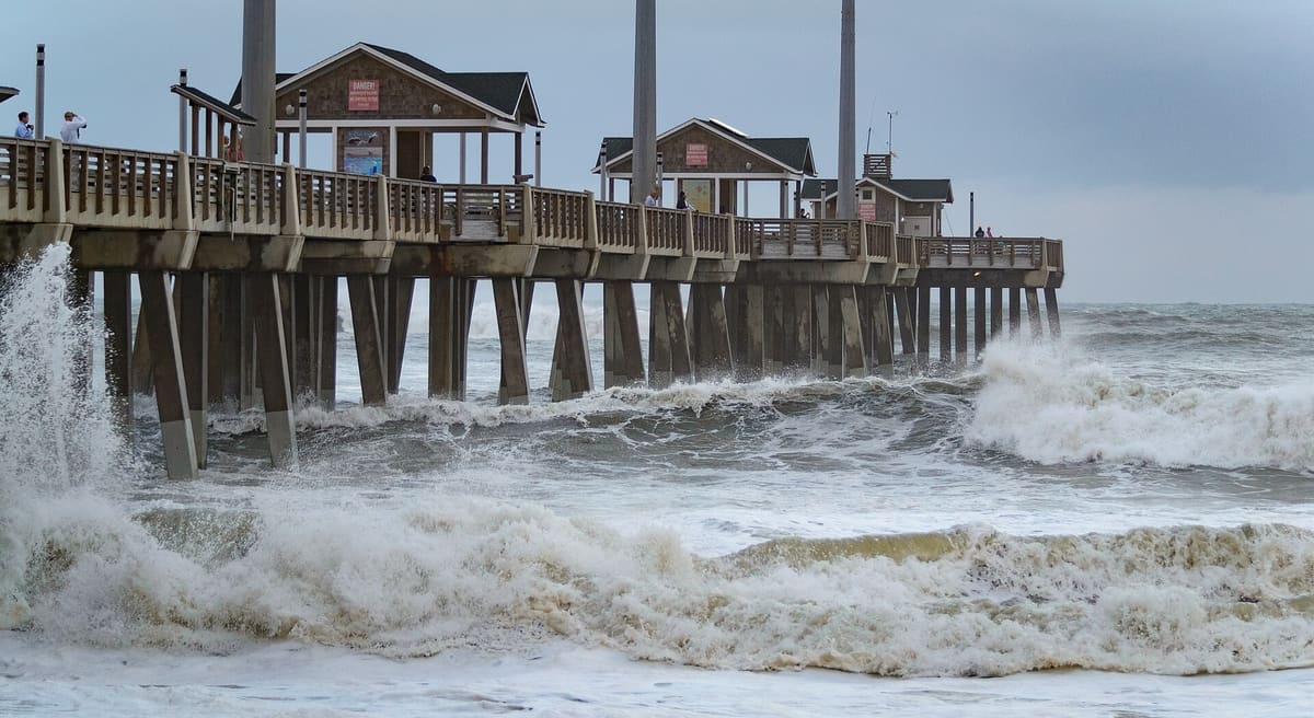 Waves breaking under the concrete pier with the pier house at its landward end