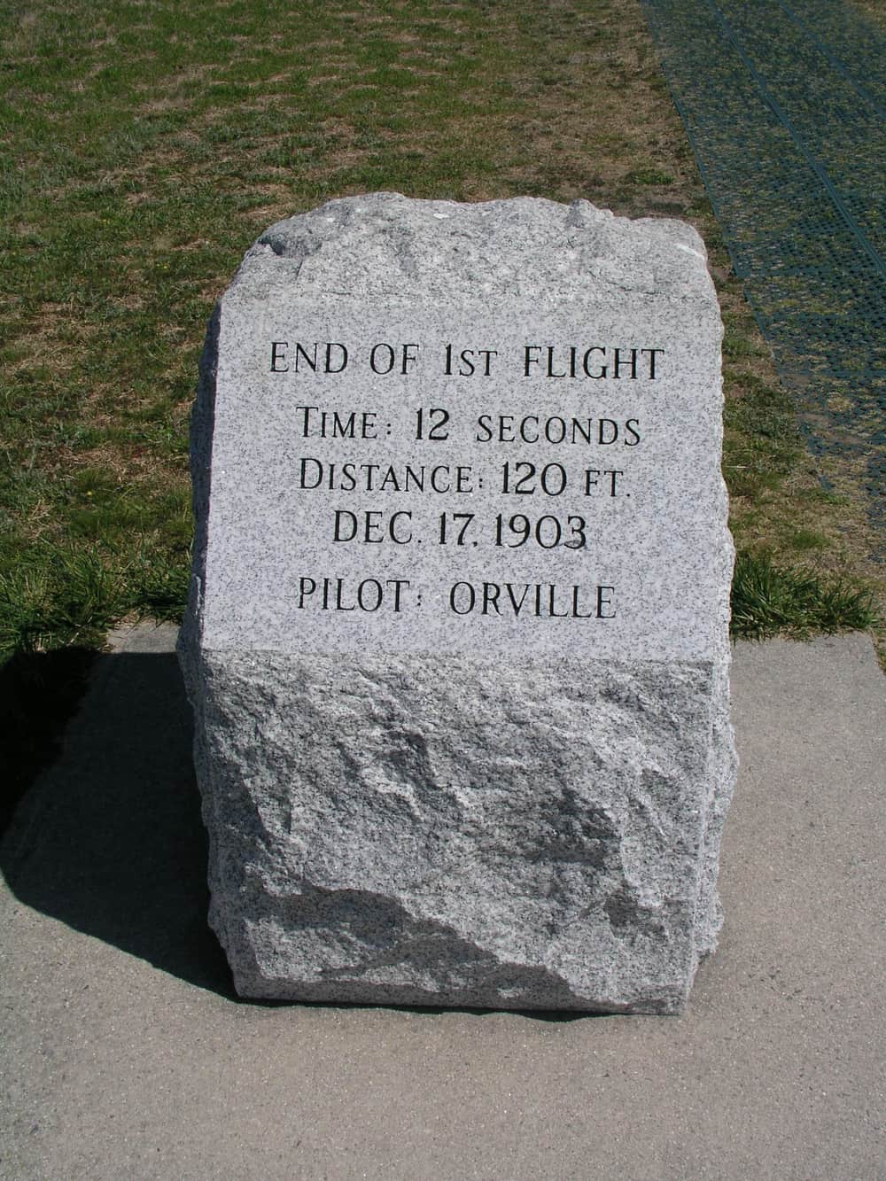 A stone marker carved with the words distance 120 ft, Dec 17 1903, pilot Orville