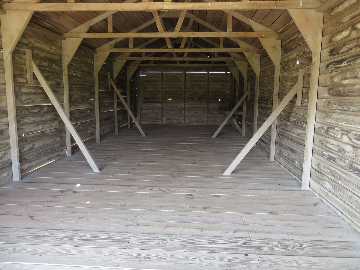 Inside one of the reconstructed wooden camp sheds looking out the open door